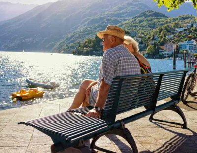 Ascona, Switzerland - August 23, 2016: Senior Couple sitting on the bench at the embankment at Ascona luxurious resort on Lake Maggiore, Ticino canton, Switzerland.