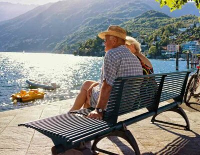 Ascona, Switzerland - August 23, 2016: Senior Couple sitting on the bench at the embankment at Ascona luxurious resort on Lake Maggiore, Ticino canton, Switzerland.