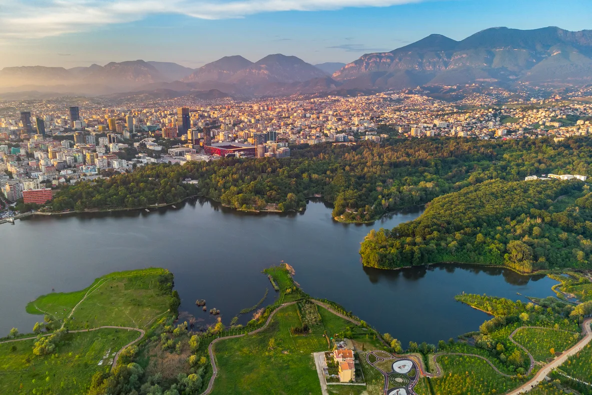Tirana from drone, dramatic sky artificial lake, Albanian Capital at sunset